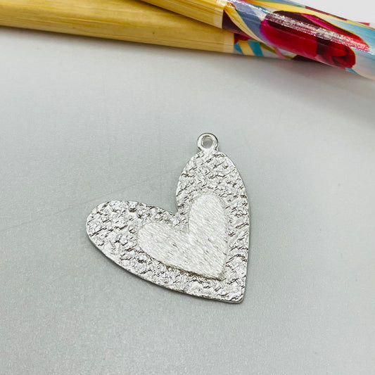 FP1078 Colgante Corazón borde martelado y en el centro corazón en relieve G 30 x 28 mm más argollita Espesor 1.2 mm Figura Baño Plata Figuras Bañadas hecho de Bronce Bañado en Plata 50 ml Joyas Bañadas en Plata