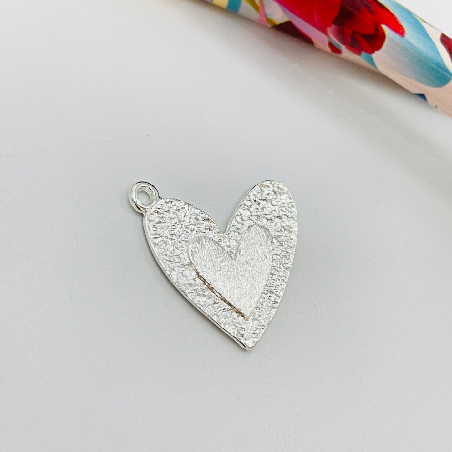 FP1077 Colgante Corazón borde martelado y en el centro corazón en relieve M 20 x 20 mm más argollita Espesor 1.2 mm Figura Baño Plata Figuras Bañadas hecho de Bronce Bañado en Plata 50 ml Joyas Bañadas en Plata