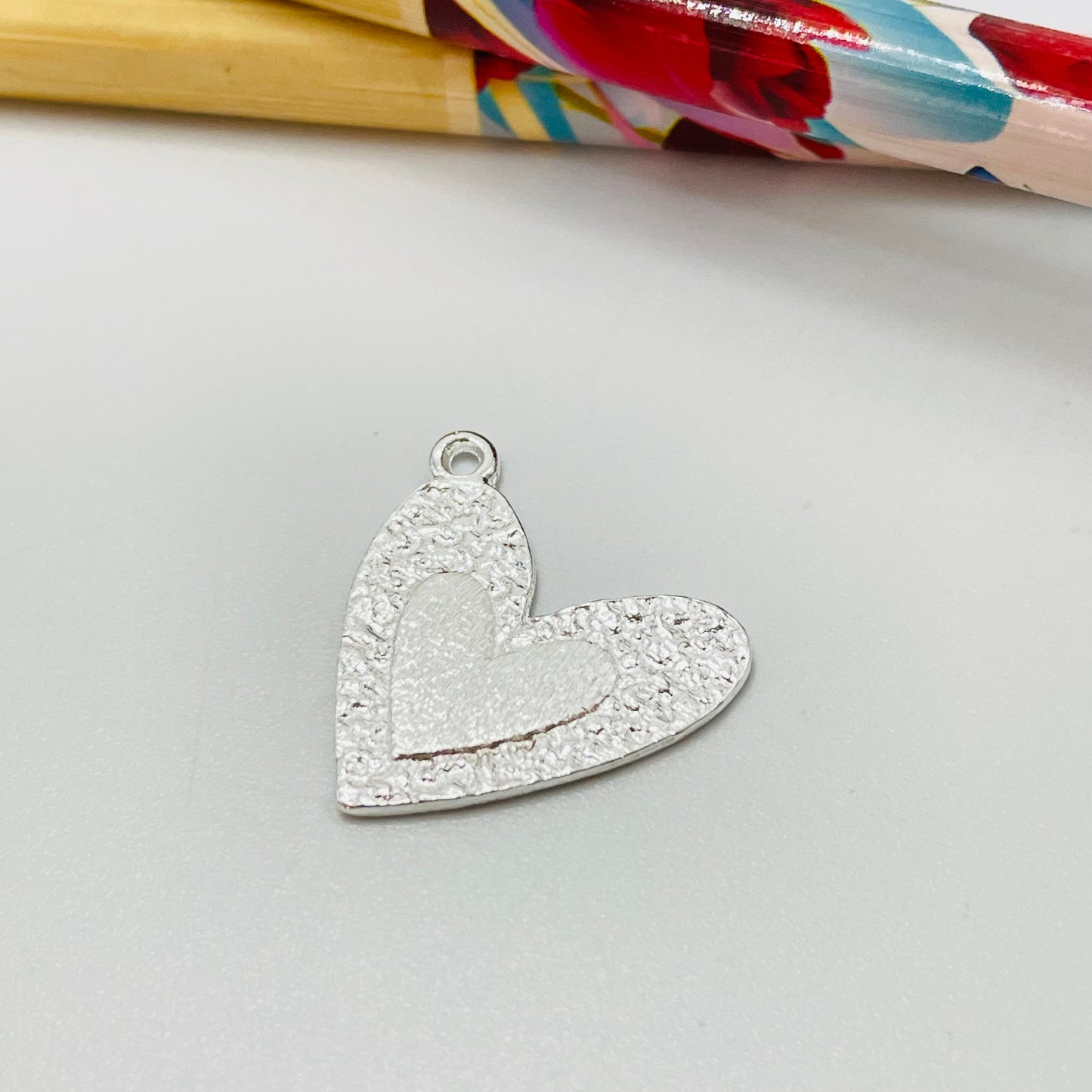 FP1077 Colgante Corazón borde martelado y en el centro corazón en relieve M 20 x 20 mm más argollita Espesor 1.2 mm Figura Baño Plata Figuras Bañadas hecho de Bronce Bañado en Plata 50 ml Joyas Bañadas en Plata